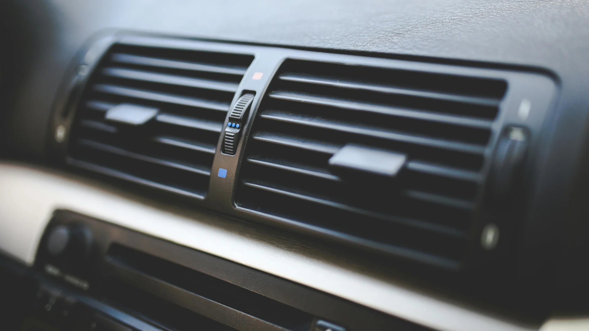Close-up of a modern automotive interior dashboard showing the air conditioning vent, representing cabin air quality and filtration systems.