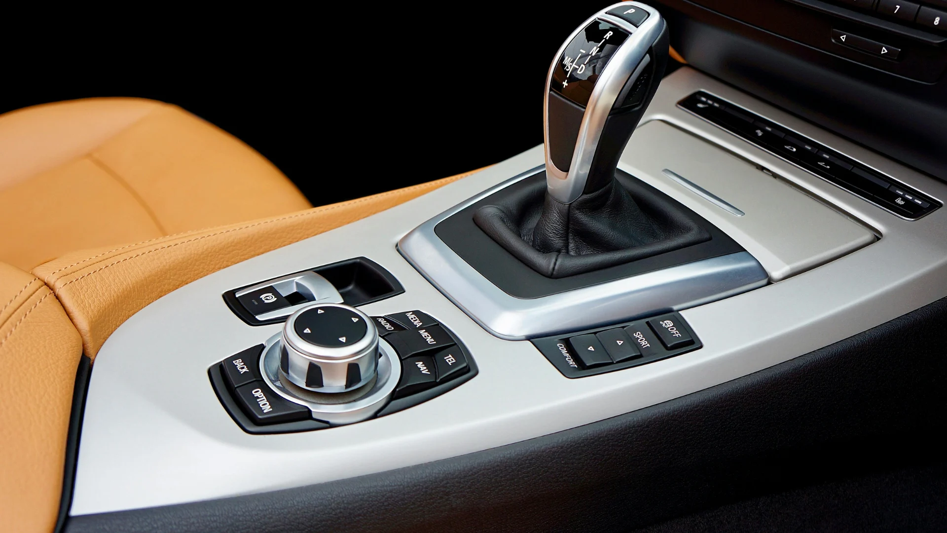 Luxury automotive interior featuring a modern center console, gear shift, and molded plastic components manufactured with reinforced industrial polymer compounds.