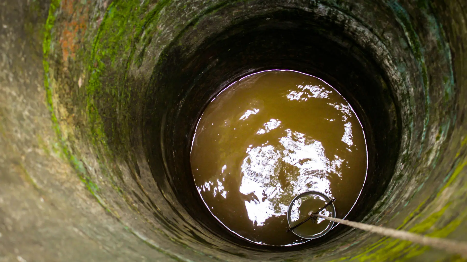 Looking down into a deep traditional water well highlighting the source for groundwater purification and treatment.