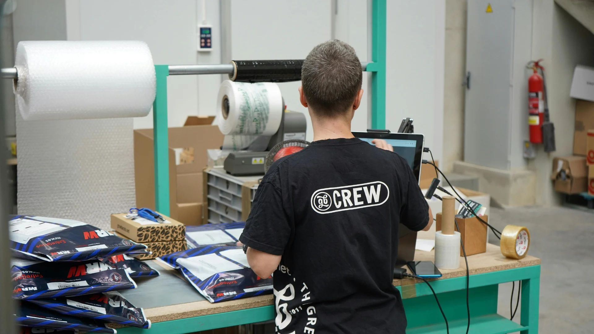 A warehouse worker processing and packaging commercial shipments at an industrial export logistics and global fulfillment center.