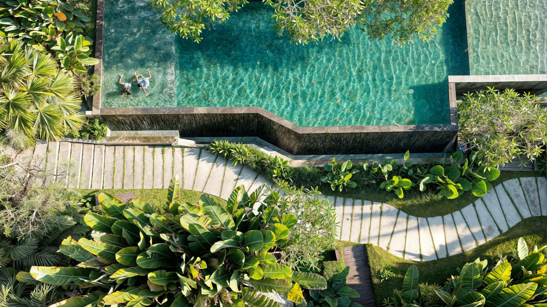 Aerial view of a luxury resort swimming pool with crystal clear water demonstrating the results of high-quality water filtration.
