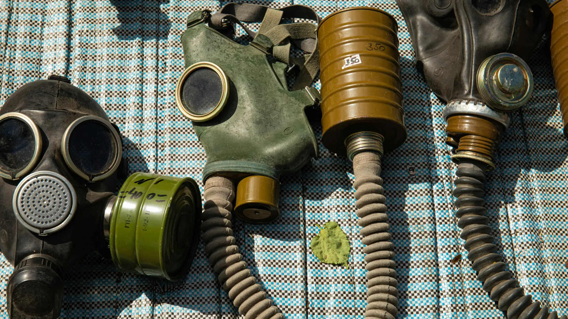 A collection of military-grade gas masks and attachable respirator canisters which utilize activated carbon for toxic gas filtration and personal protection.