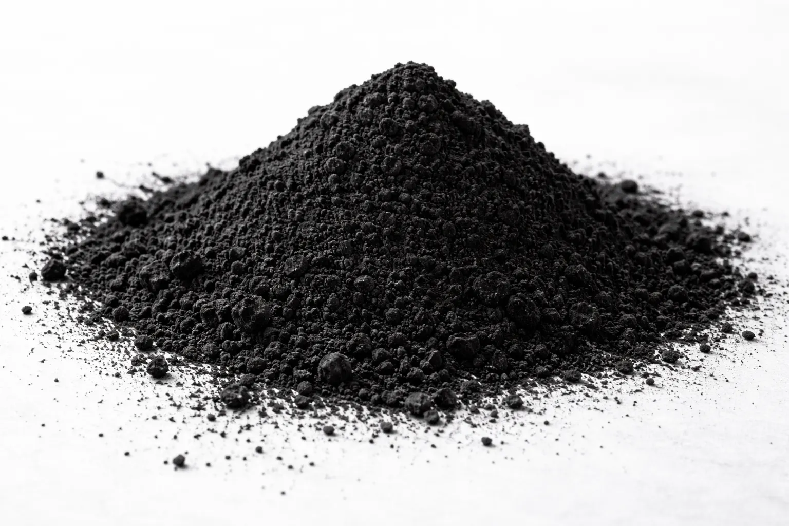 Macro photograph of a mound of premium specialty carbon black powder on a white surface, highlighting the fine particulate texture used in high-performance industrial pigments, plastics, and conductive coatings.